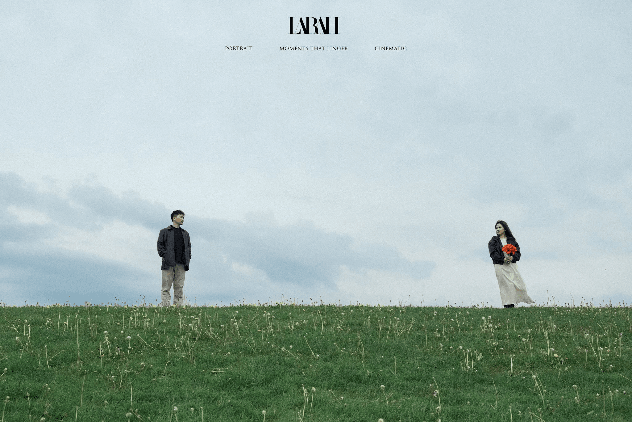 Two people standing apart in a wide green field